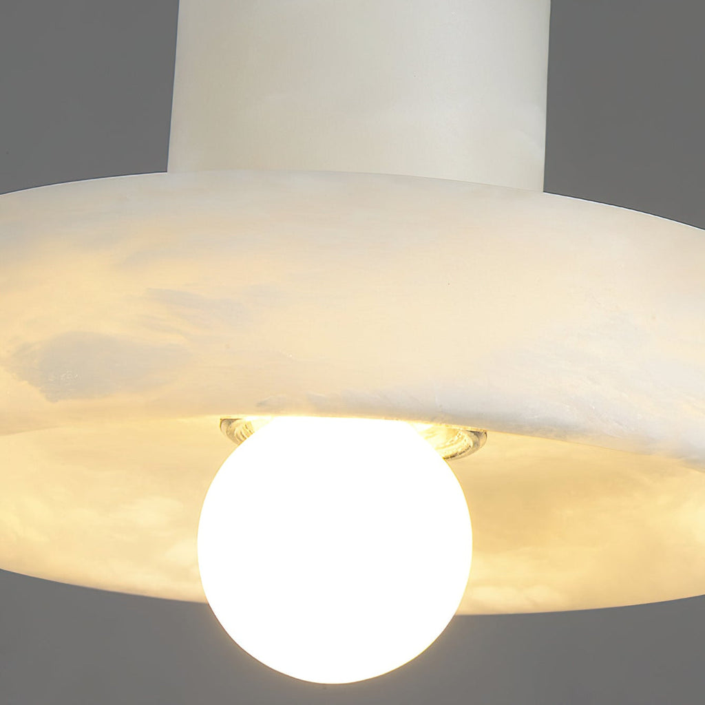 Close-up beneath the brim, showing the translucent alabaster glowing around the globe bulb.