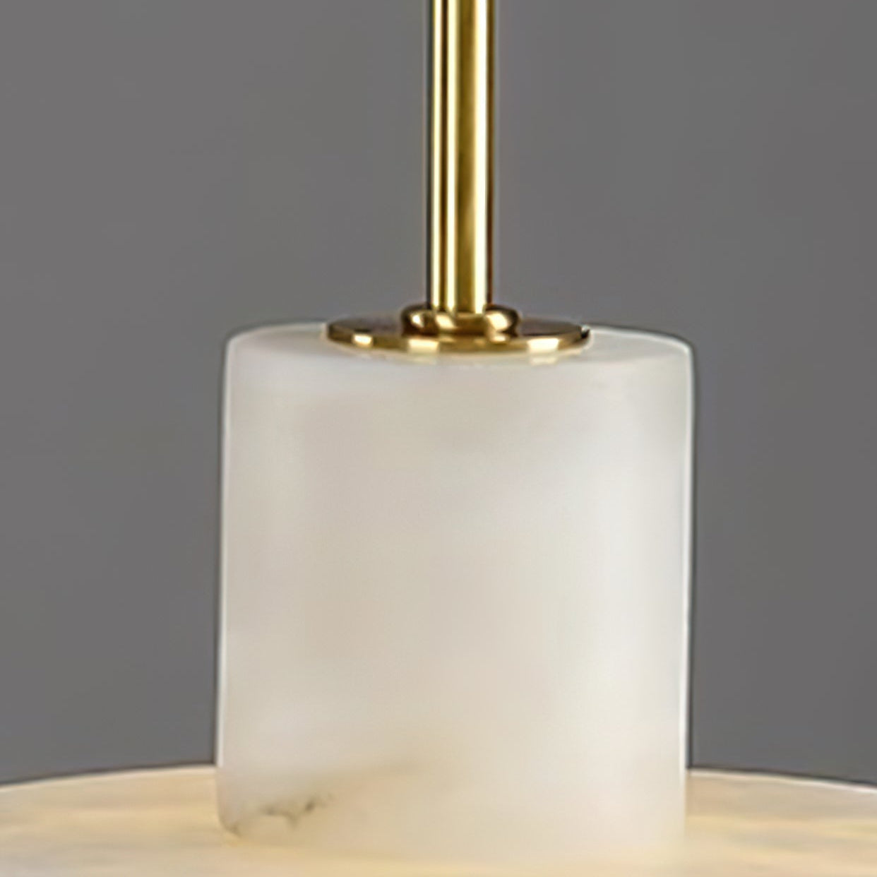 Detail of the alabaster cylinder and the polished brass stem fixed into its top.