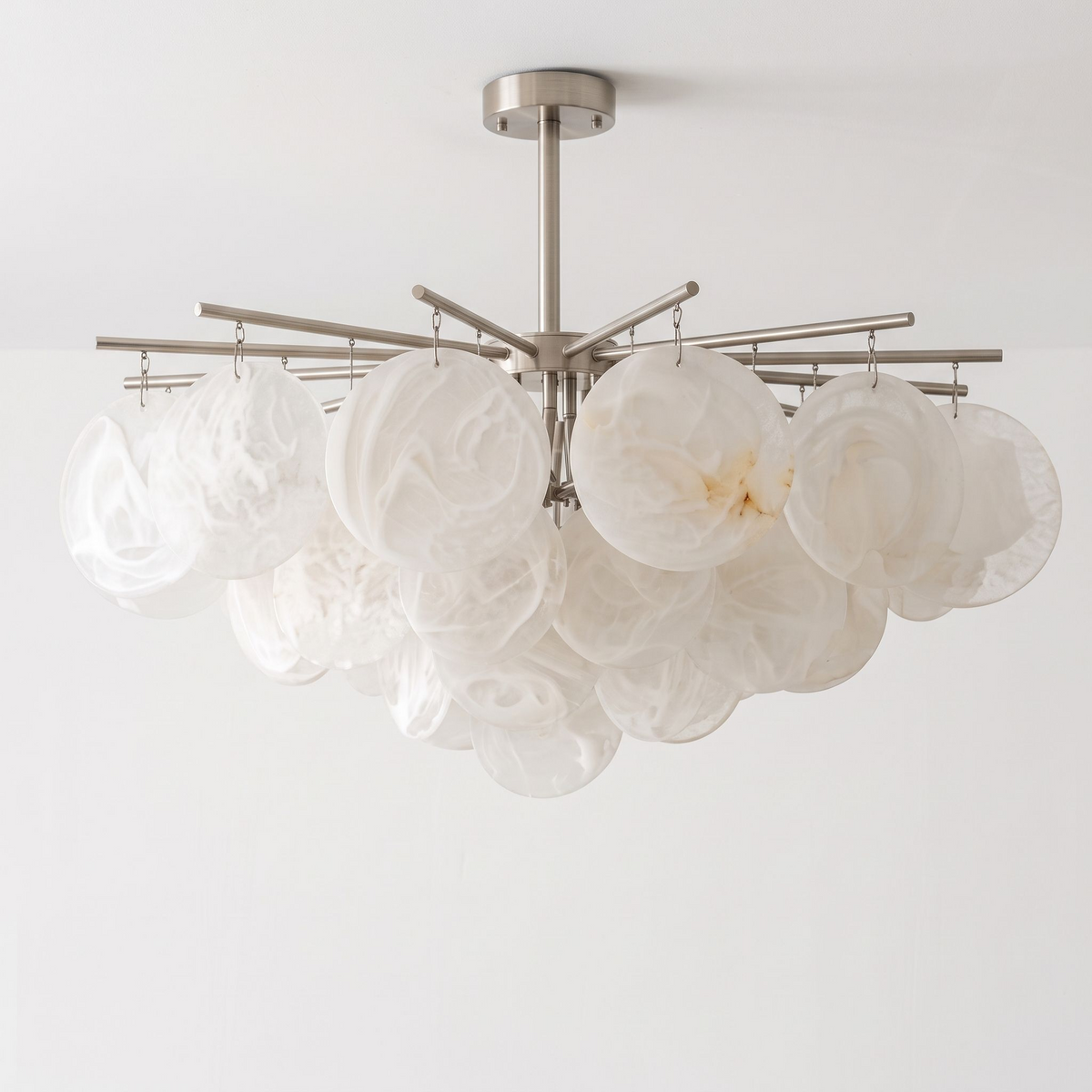 Against a plain white background, this nickel Clérachic chandelier hangs unlit, its alabaster discs clustered densely at the centre.