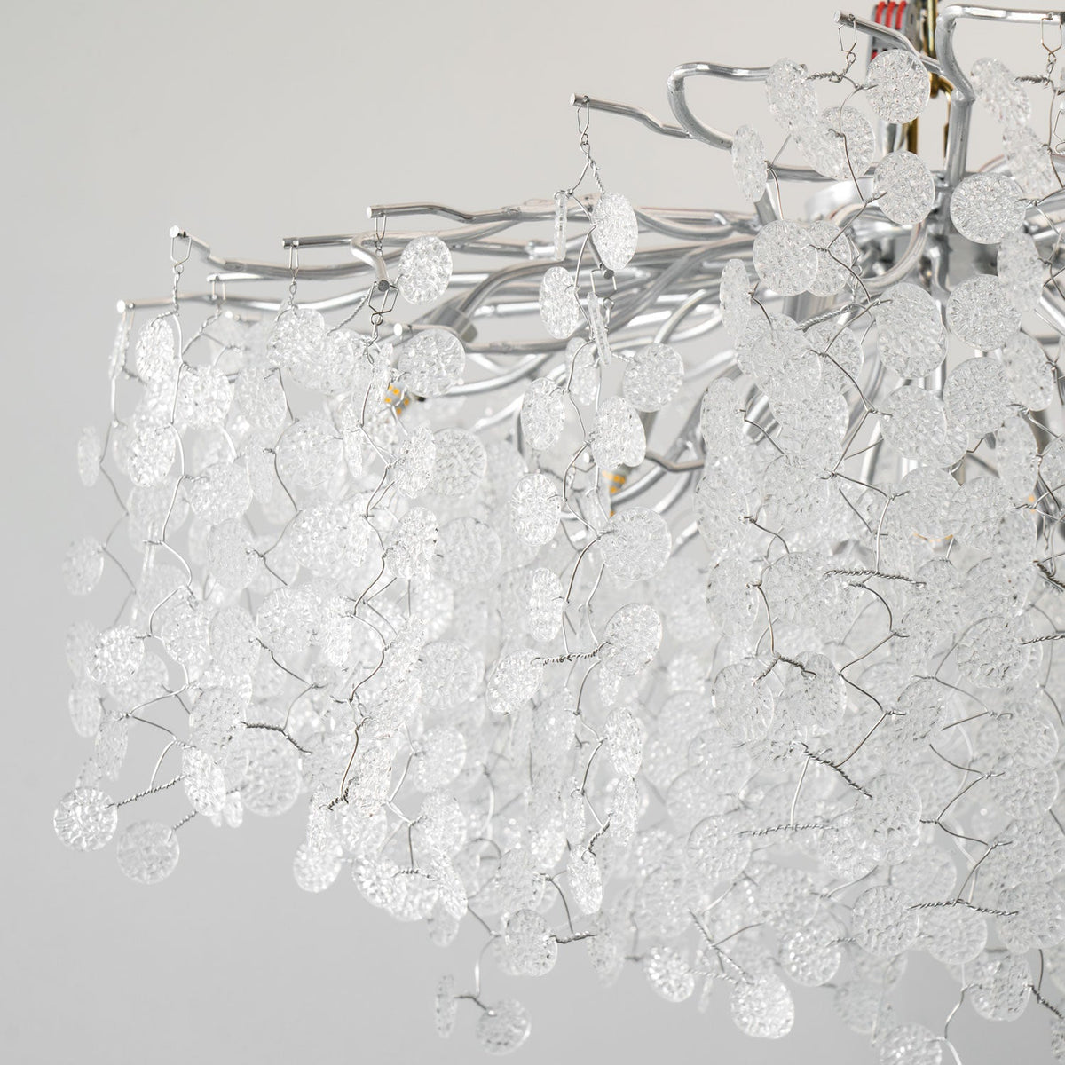 Close view of the silver branches on this Clérachic ceiling light, densely hung with unlit clear glass discs.