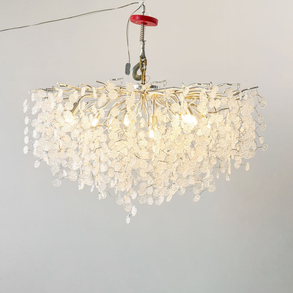 Lit against a plain grey backdrop, this Clérachic ceiling light in silver glows through its clear glass discs, hung from a test rig.