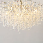 Close view of the silver branches and clear glass discs on this Clérachic ceiling light, glowing warm from within.