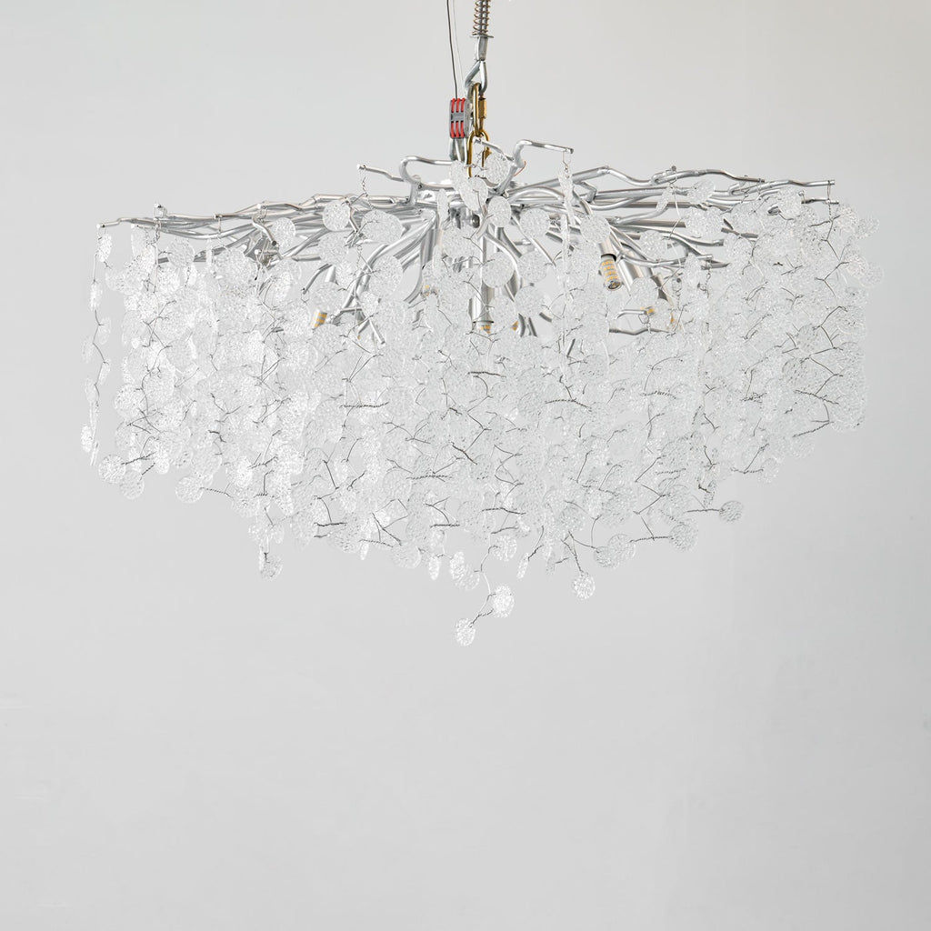 Unlit against a plain grey backdrop, this Clérachic ceiling light in silver hangs from a test rig, its clear glass discs still.