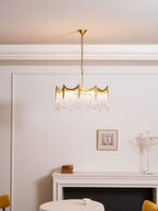 Copper-finish chandelier with clear glass shades lit in a warm room