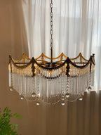 Copper chandelier with clear glass shades shown from a low angle