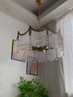 Detail of warm copper arms and clear glass shades on the chandelier