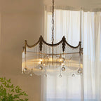 Detail of copper chandelier arms holding clear glass globe shades