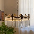 Copper-finish chandelier with clear glass shades illuminated in a living room