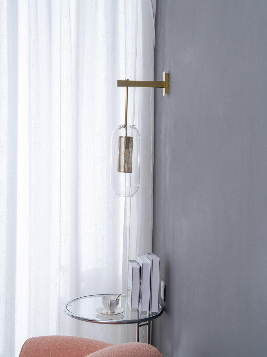 Brass-finish glass wall lamp shown against a soft backdrop
