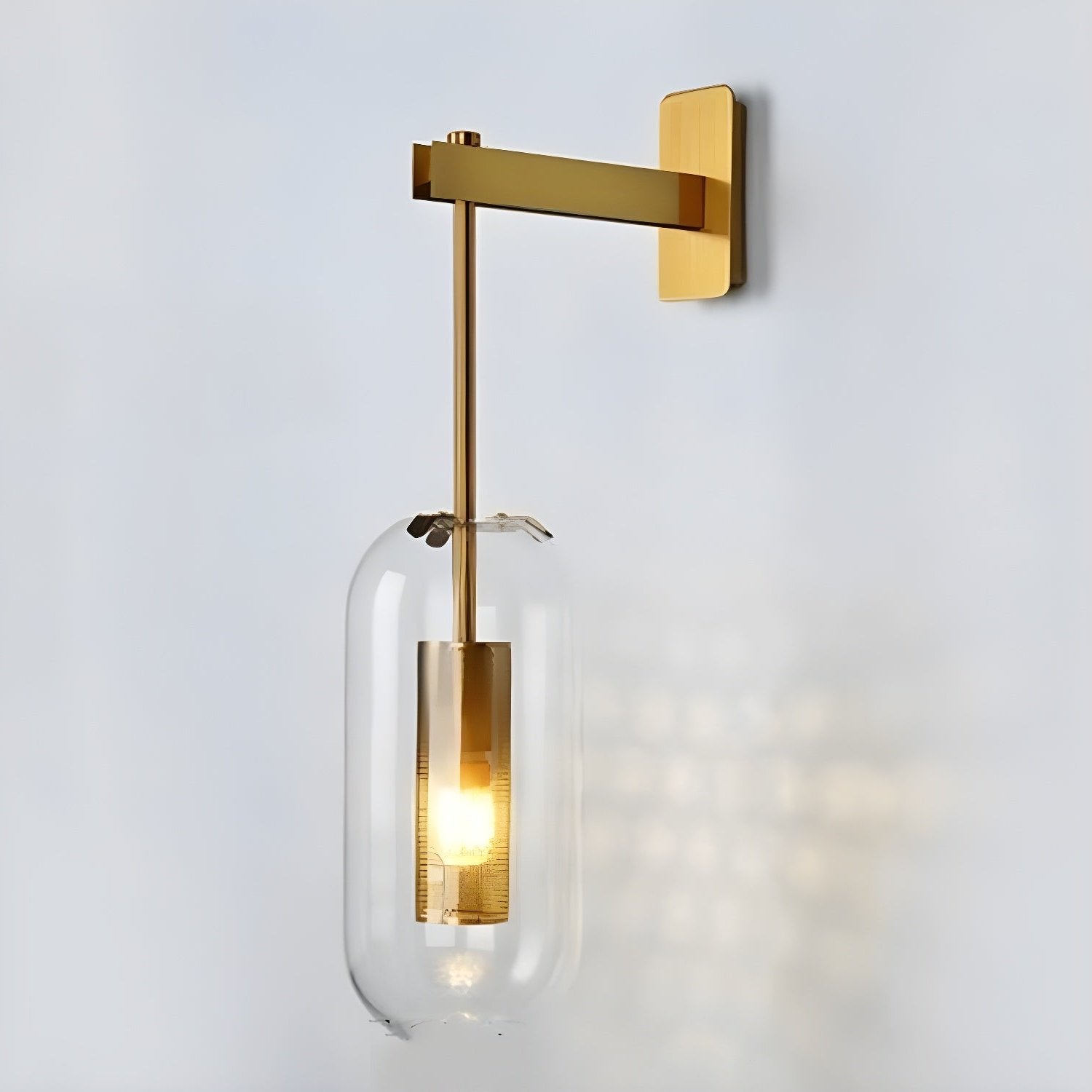 Glass wall lamp with copper arm and clear shade mounted on a bright wall