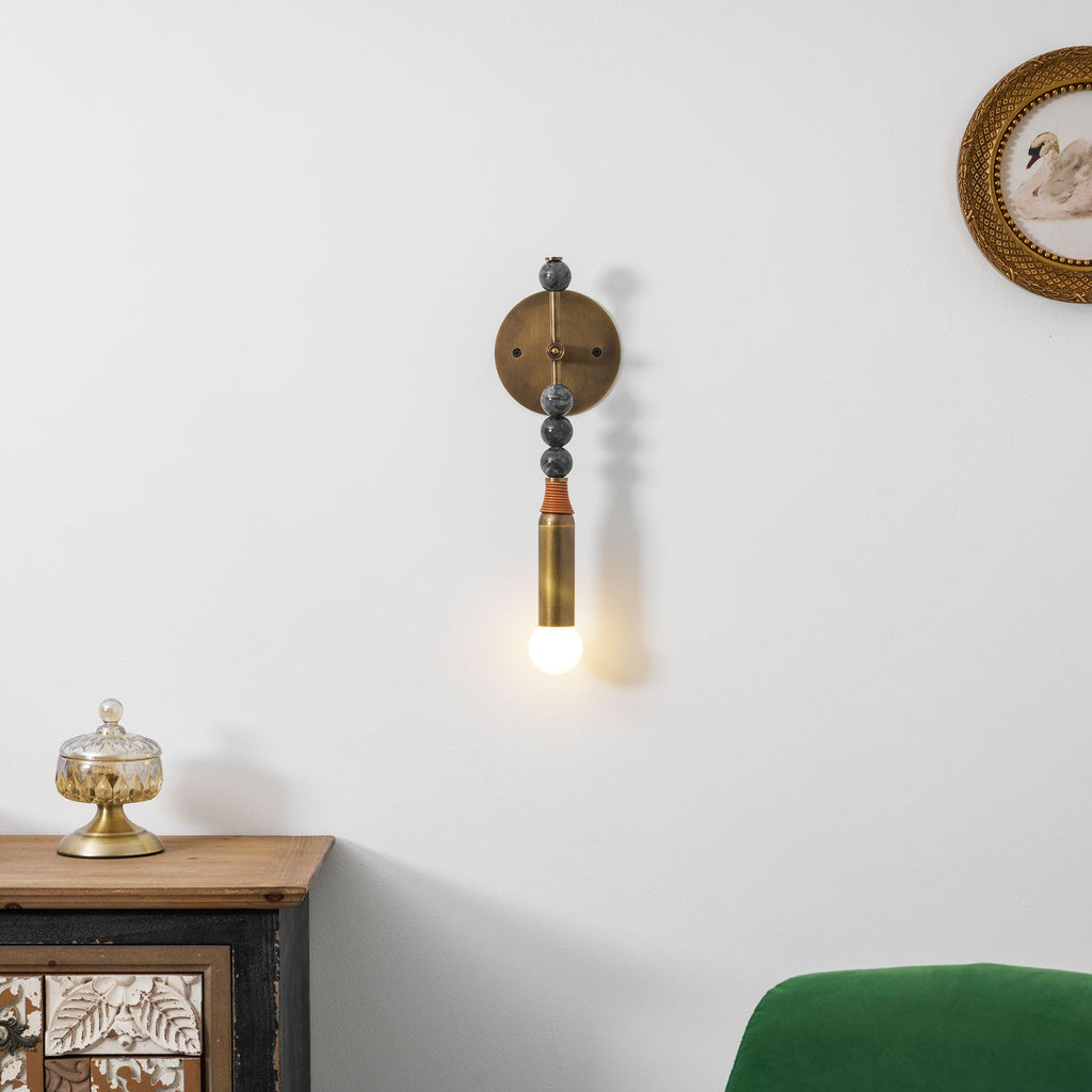 Antique brass and marble wall lamp shown in a styled setting