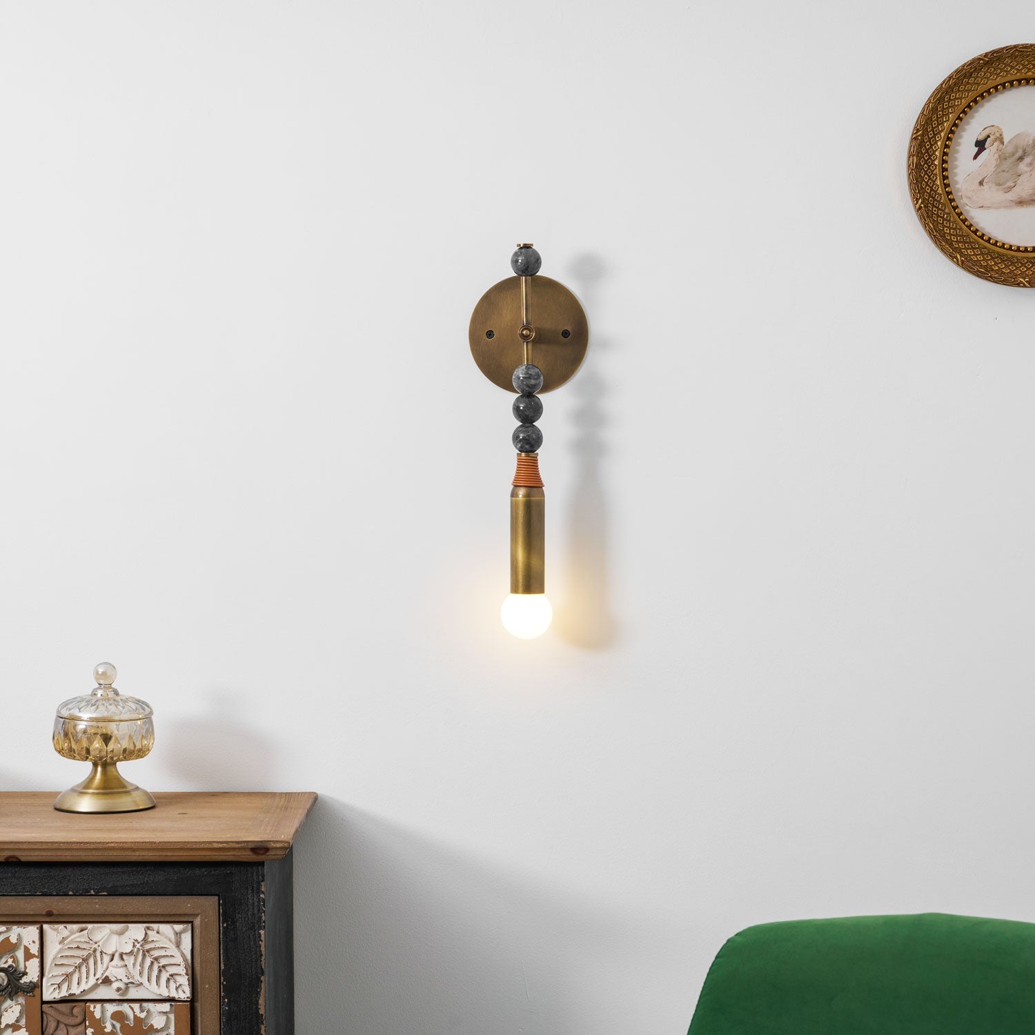 Antique brass and marble wall lamp shown in a styled setting