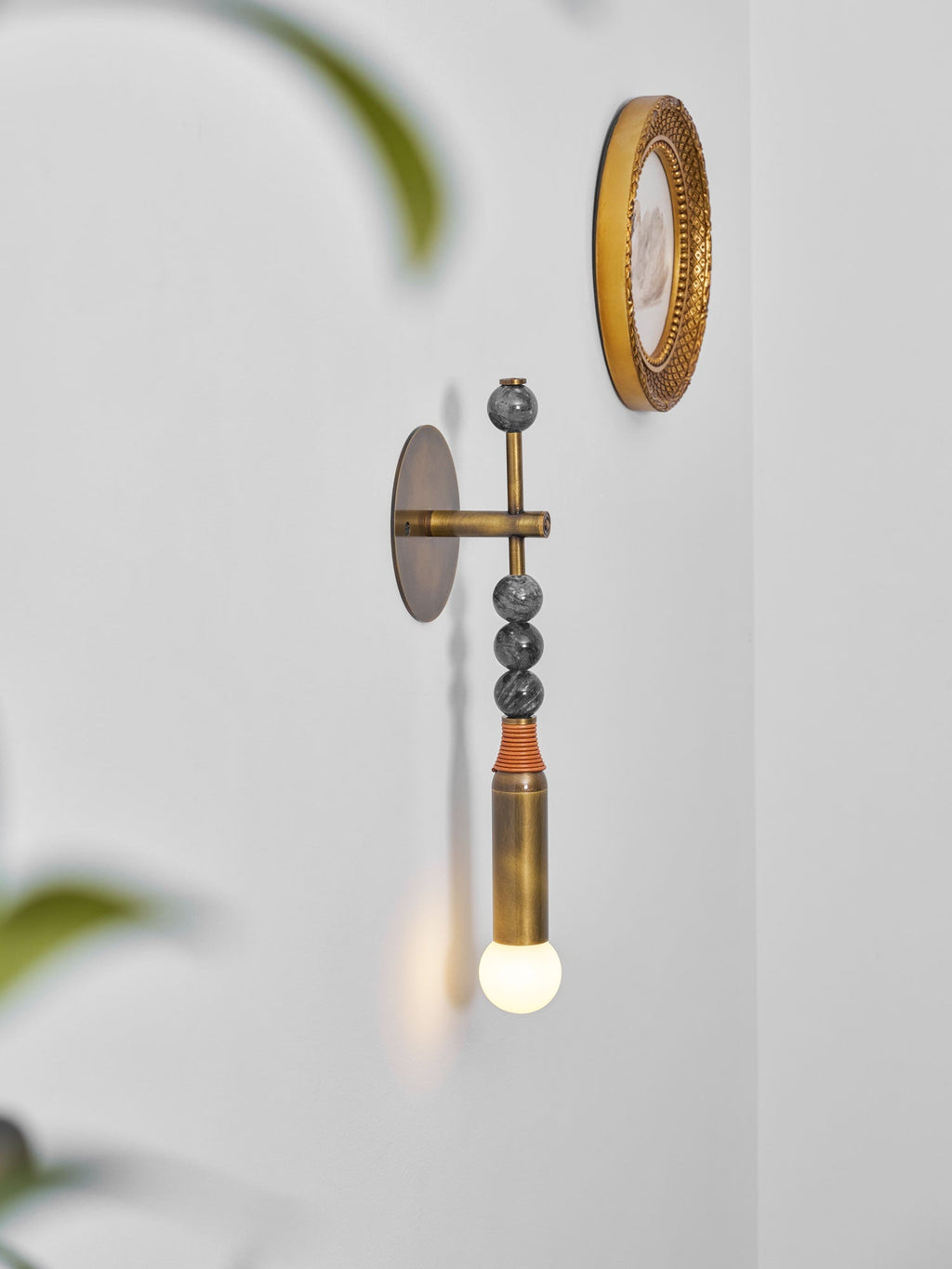 Brass wall sconce with stone detail casting soft warm light