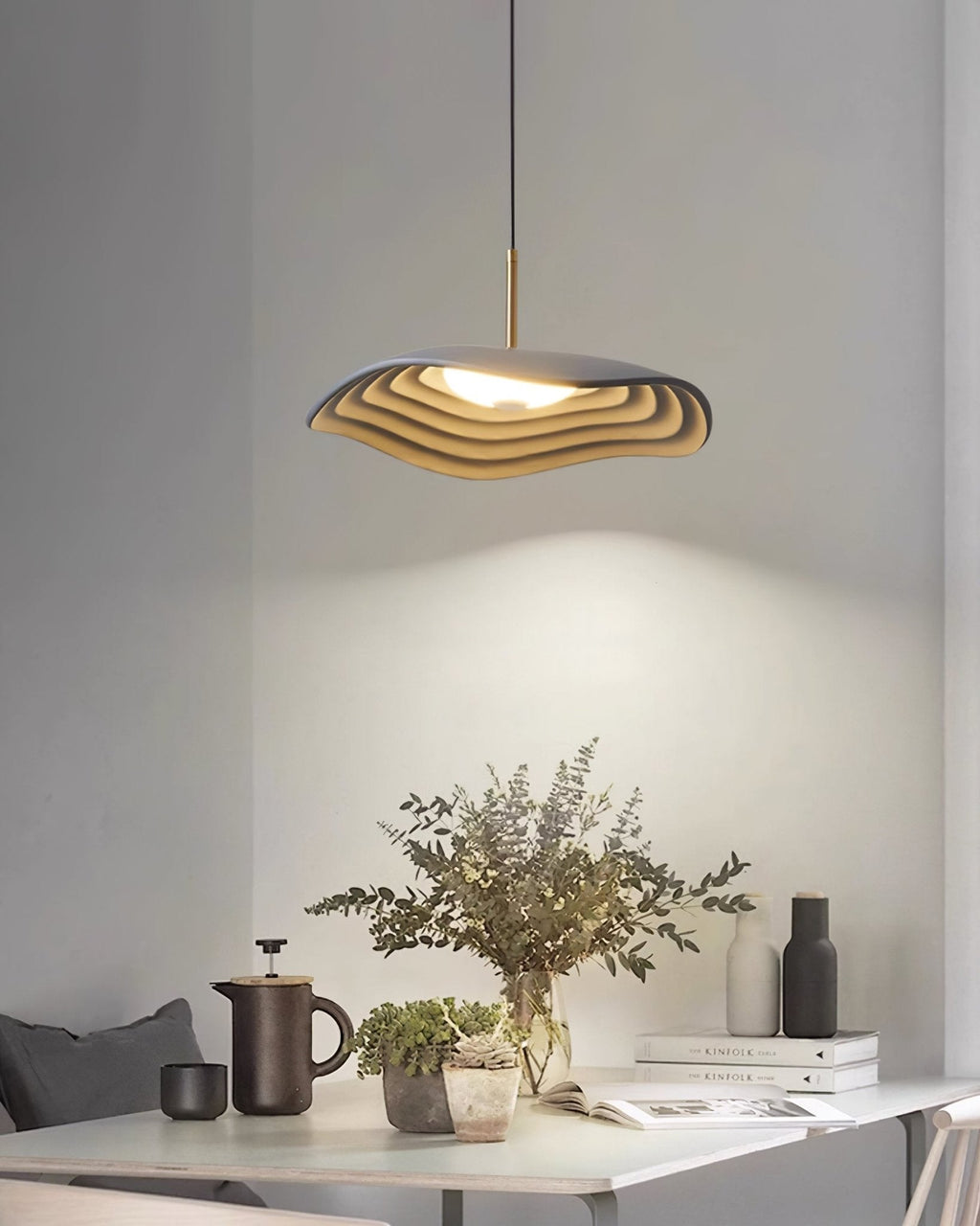 Disc pendant light glowing softly against a pale wall