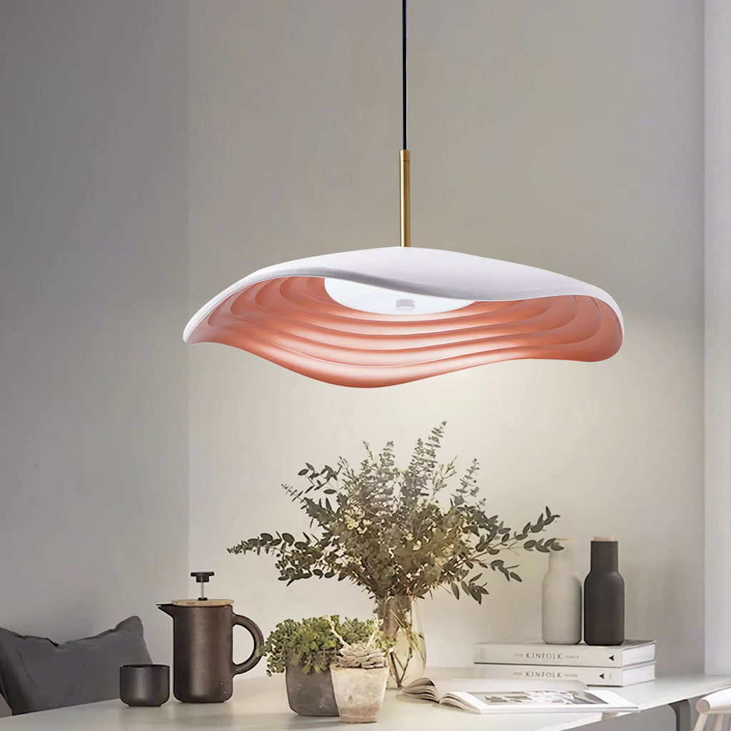 Red pendant light with disc shade suspended in a bright room