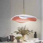 Red pendant light with disc shade suspended in a bright room