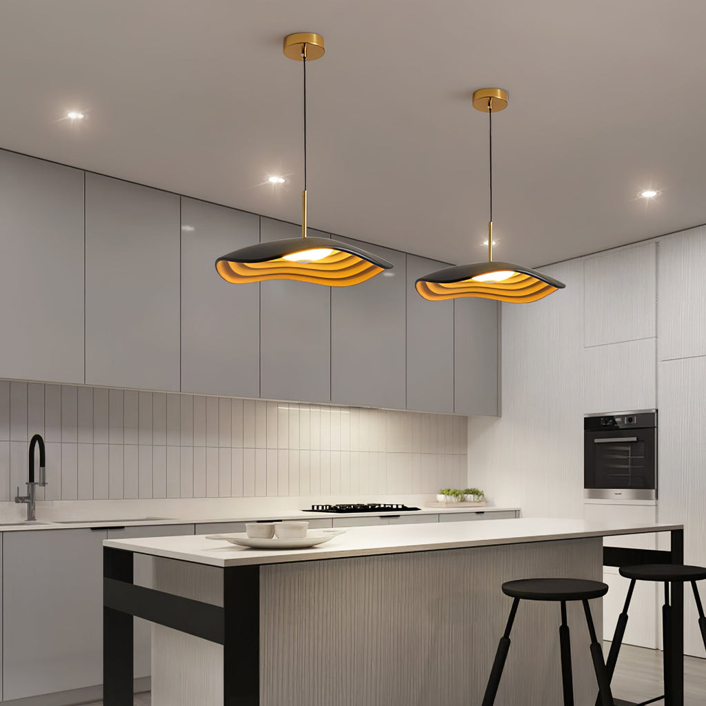 Pendant light suspended above a kitchen island casting warm glow