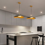 Pendant light suspended above a kitchen island casting warm glow