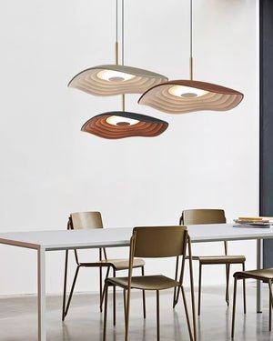 Black disc pendant light suspended in a minimal interior