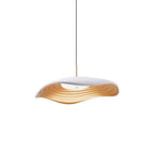 Black pendant light with slim cord suspended over a dining table
