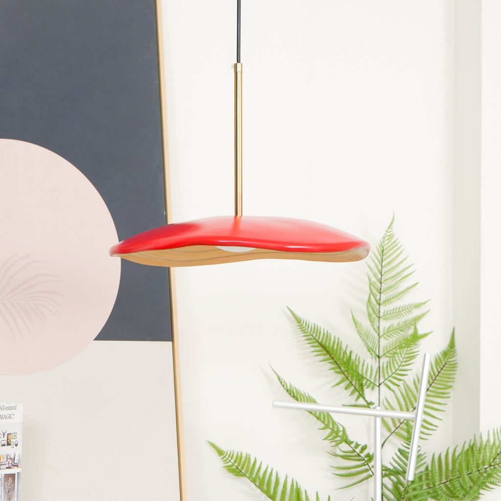 Pendant light with clean disc shade shown against a wall