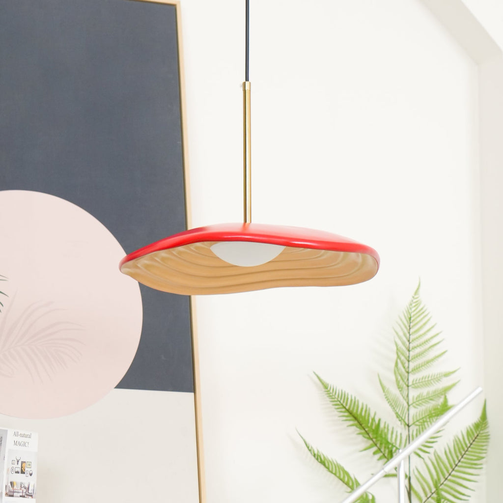 Disc pendant light suspended above a modern dining table