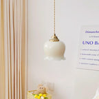 Petal-shaped brass pendant light suspended in a cozy space