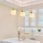 Flower-shaped brass pendant light hanging in a styled interior