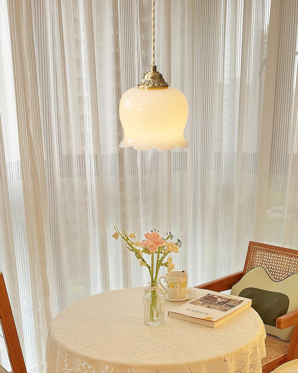 Brass flower pendant light with white shade in a soft setting