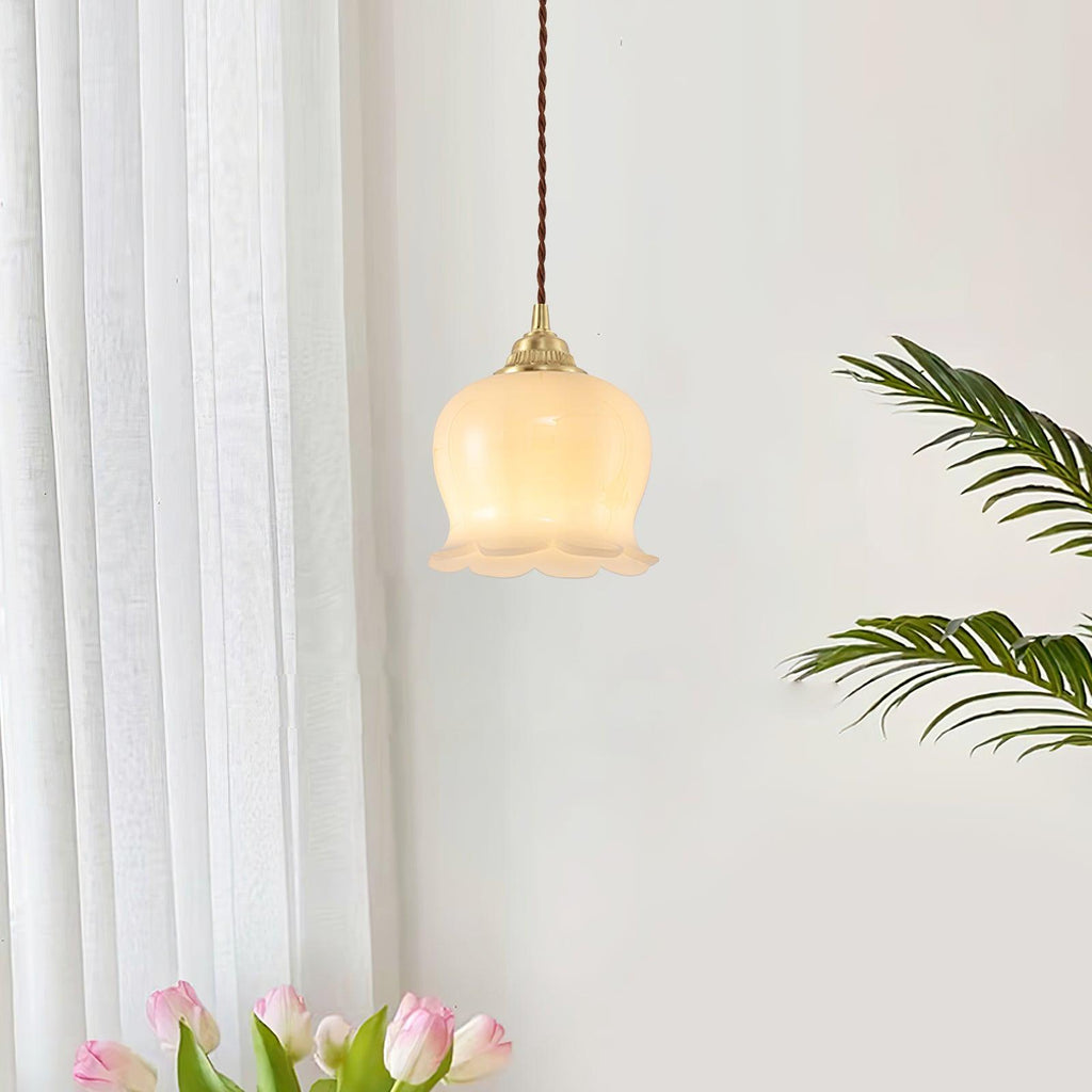 Petal pendant light in brass casting warm light over a table