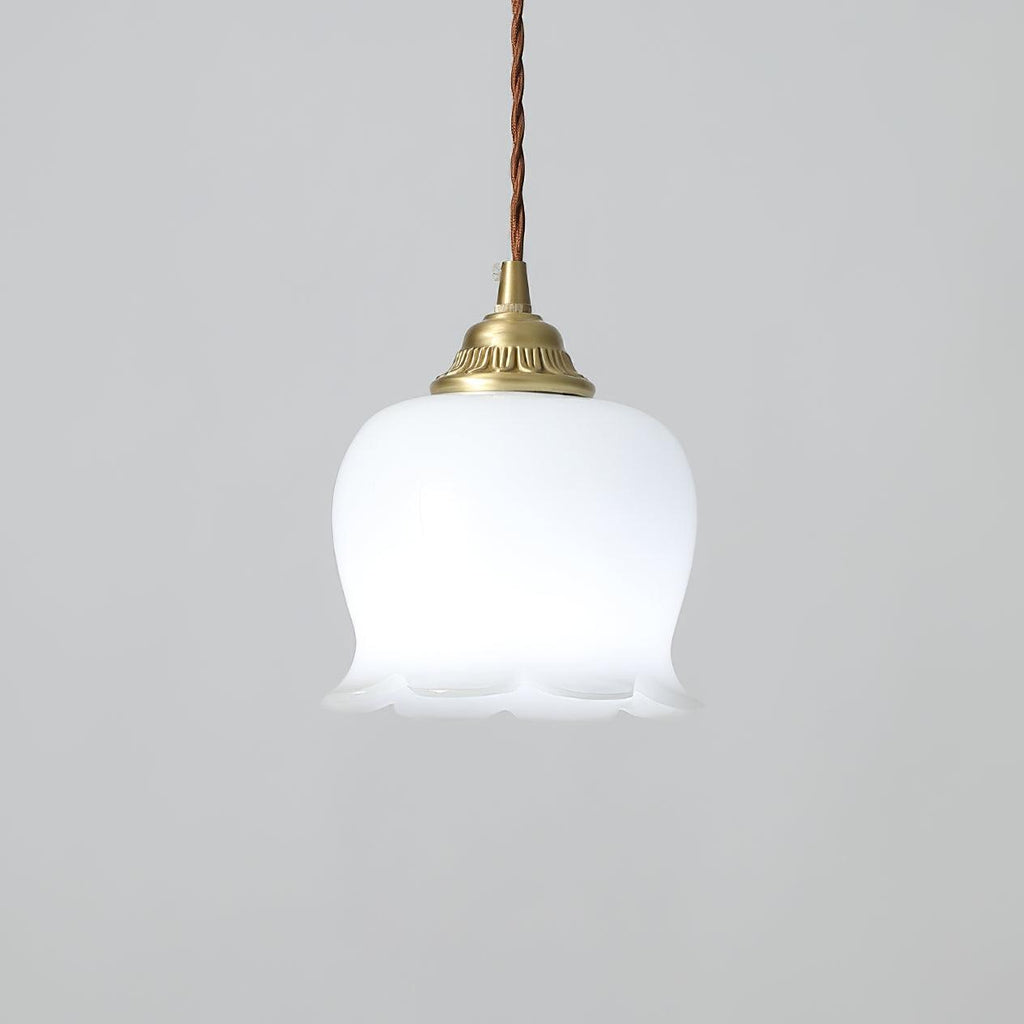 Brass pendant light with white petal shade glowing in a soft interior