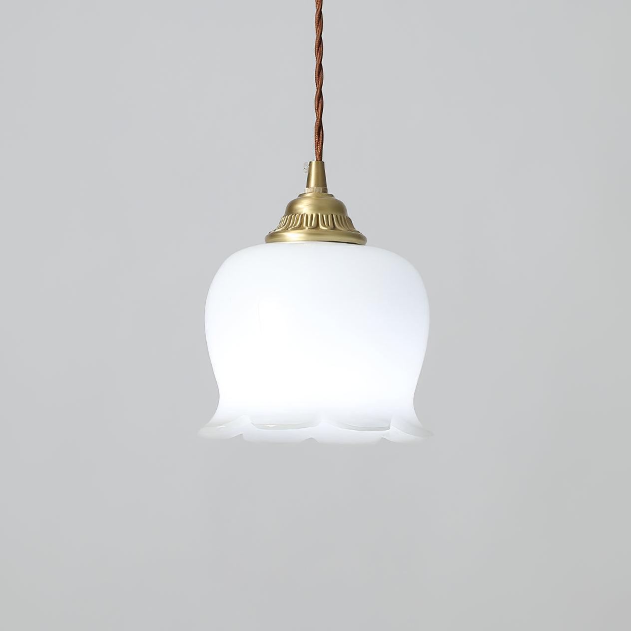 Brass pendant light with white petal shade glowing in a soft interior