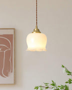 Petal-shaped pendant light in brass glowing warmly indoors