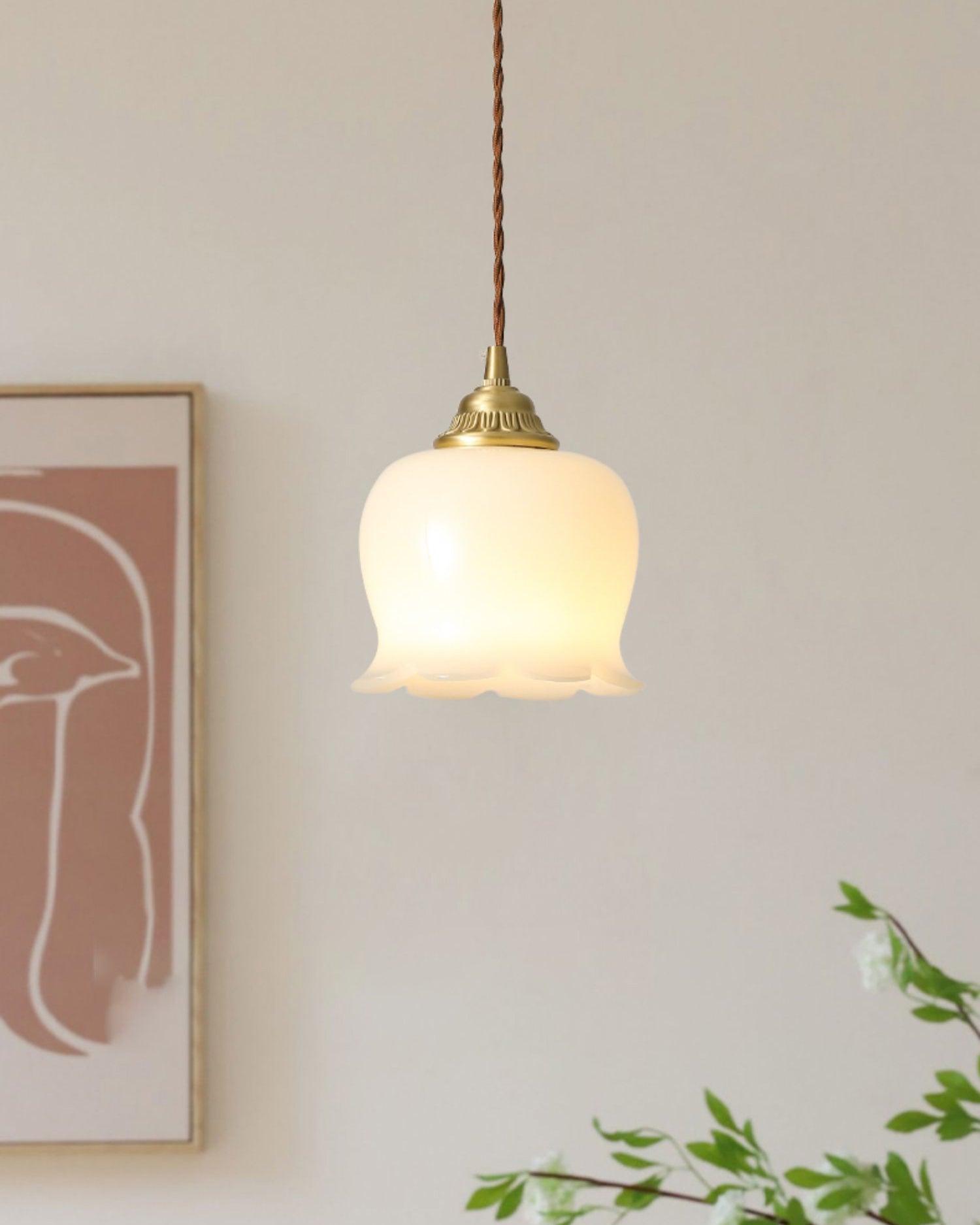 Petal-shaped pendant light in brass glowing warmly indoors