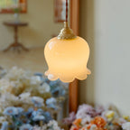 Petal pendant light in brass suspended near a wall corner