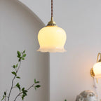 Flower-shaped brass pendant light casting a warm glow
