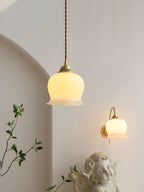 Brass flower pendant light glowing softly above a side table
