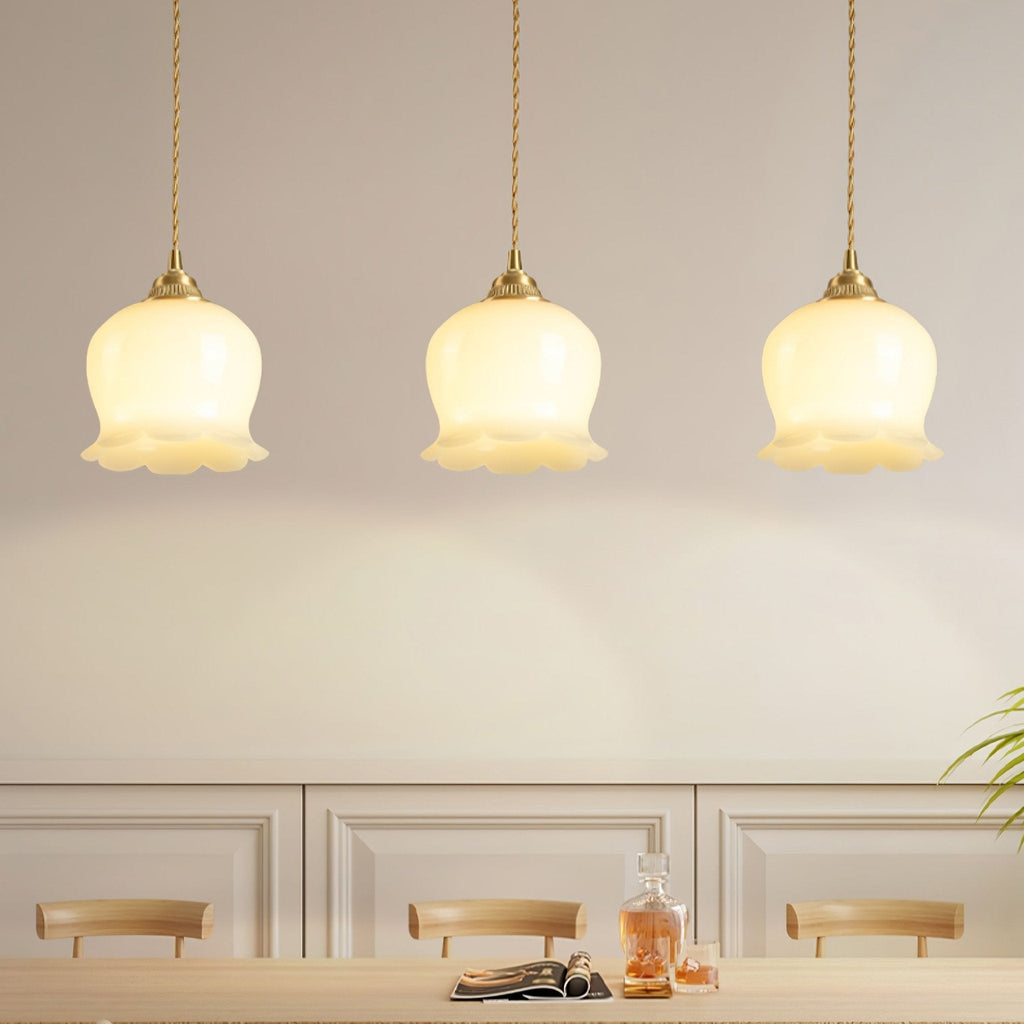 Brass swag pendant light with petal shade hanging beside a wall