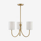 Studio shot of this Clérachic chandelier in brass finish, its three alabaster cylinder shades on curved arms, against white.