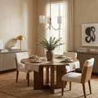 Beneath a black abstract print, this Clérachic chandelier in brass finish hangs over a round dining table.
