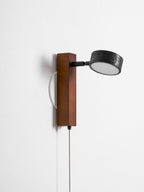 On white, this Clérachic wall light has its head swivelled fully to the side, cord hanging below.