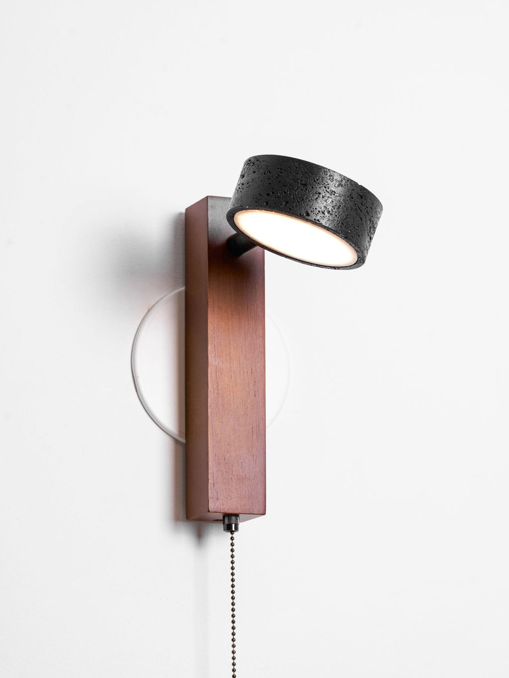 On white, this Clérachic wall light has its head tilted upward at an angle on the walnut arm.