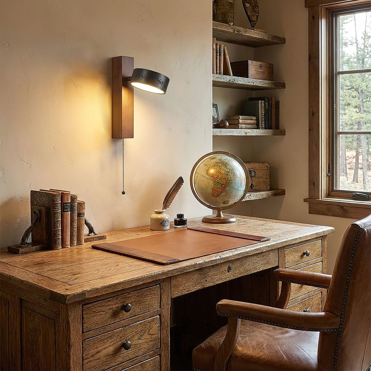 Above a wooden desk set with a small globe, inkwell and books, this Clérachic wall light glows warm.