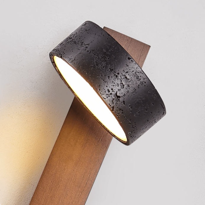 Extreme close view of the black travertine drum shade on this Clérachic wall light, its stone-like texture visible.