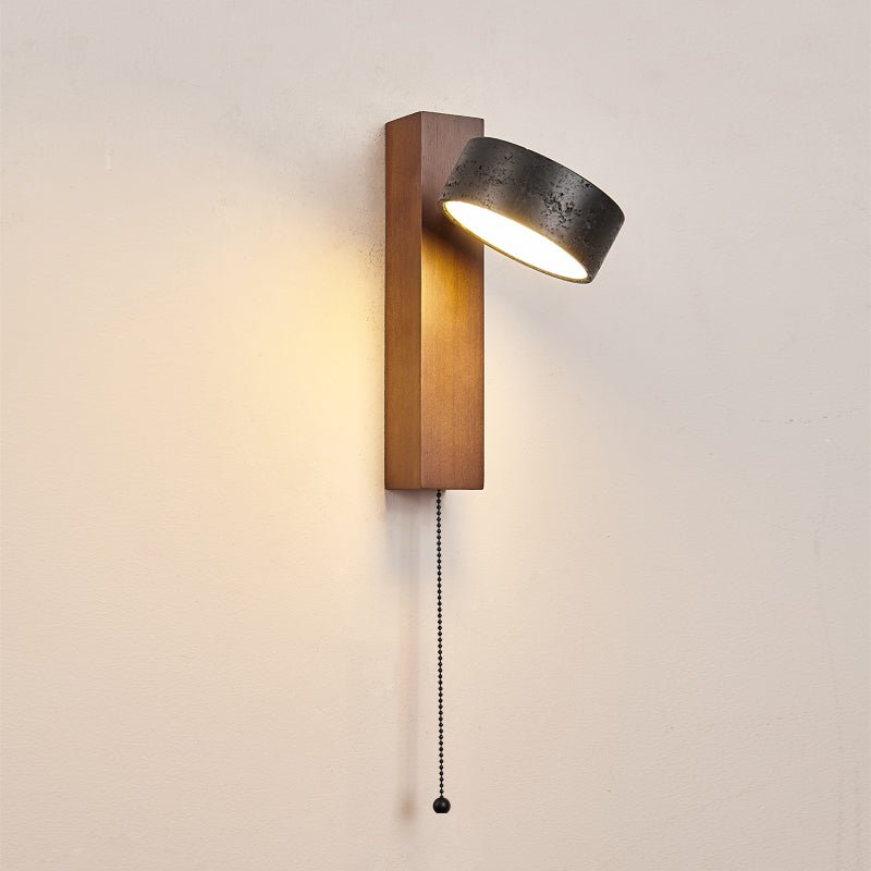 Close shot of this Clérachic wall light on a plain wall, its pull chain hanging and the head angled downward.