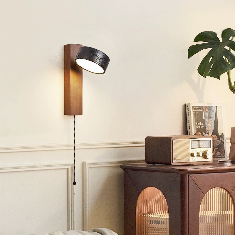 A credenza holding a vintage radio and a potted plant sits beneath this Clérachic wall light, glowing warm.