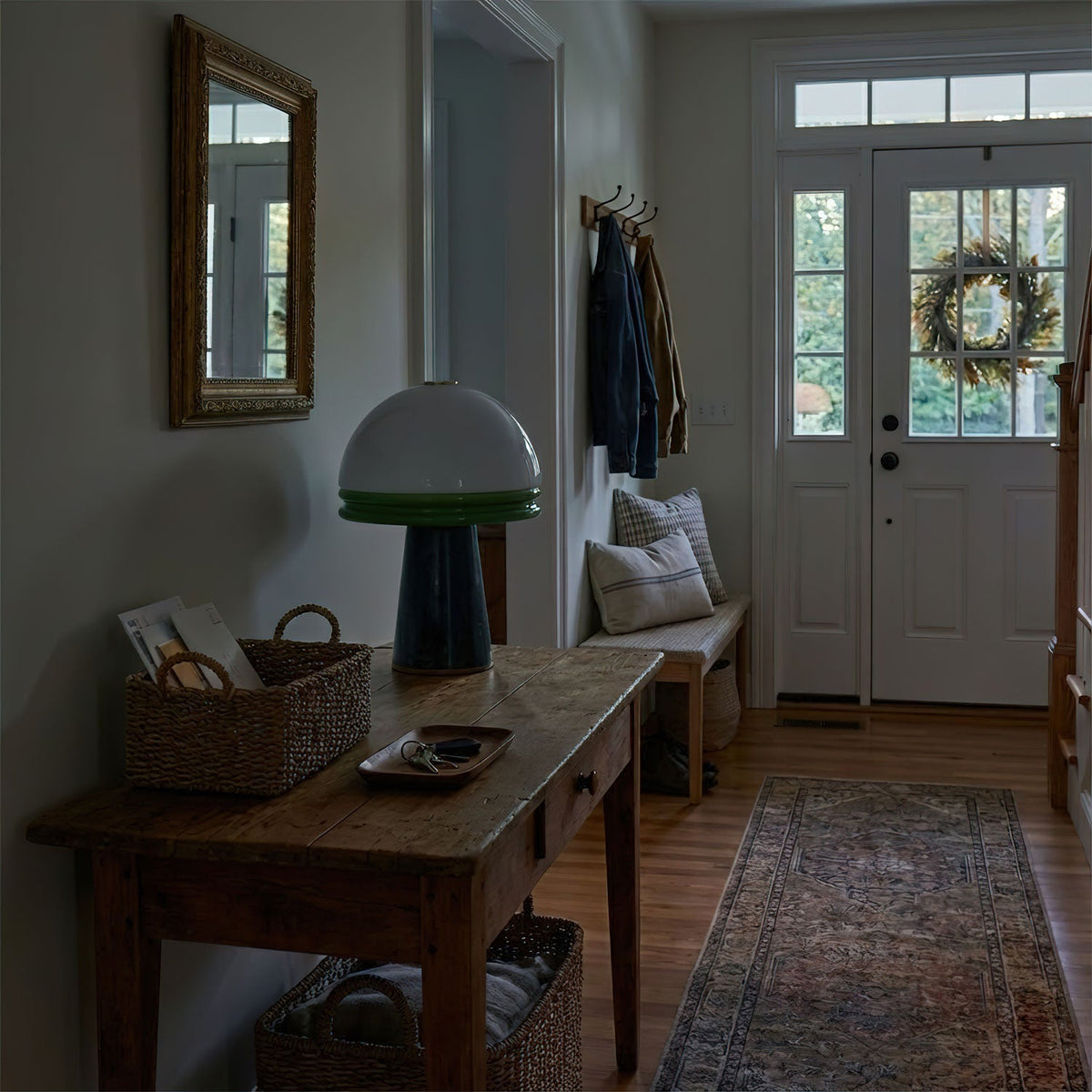 Lit on a console table in a dim entryway, this Clérachic table lamp sits near a woven basket by the front door.