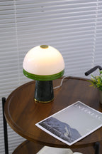 Zoomed out, the Clérachic table lamp stands on a two-tier round table with a folded throw on the shelf below.