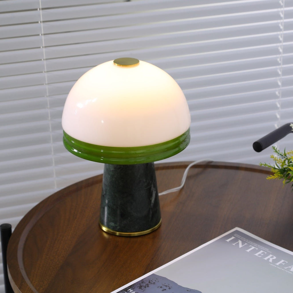 The Clérachic dome lamp glows on the round table, its cord trailing to the right past the blinds.