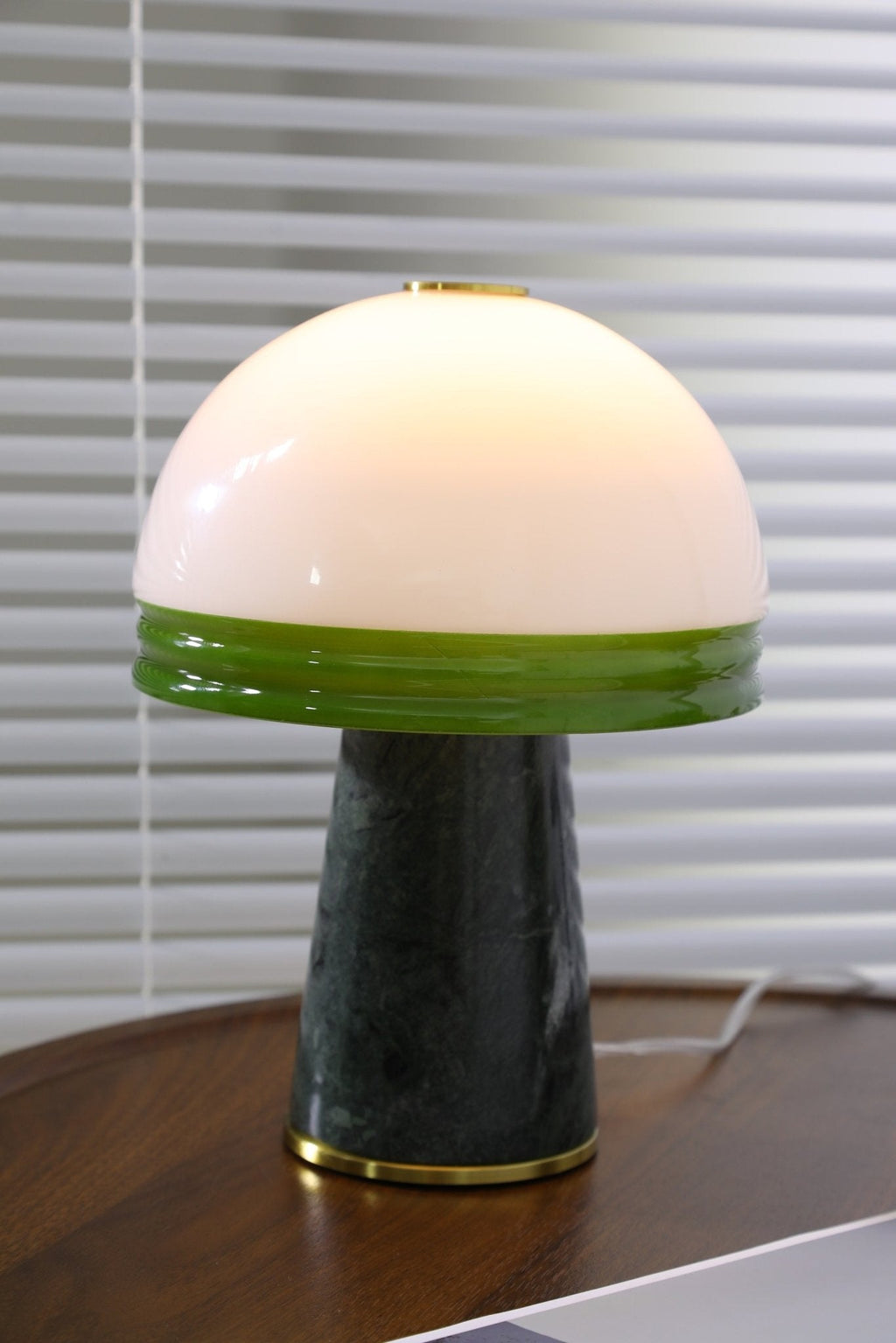 An isolated, close view of the Clérachic dome lamp lit on the round table with no other props in frame.